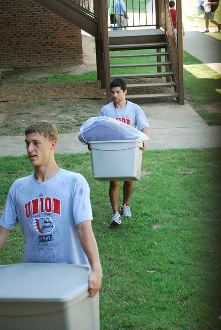 Soccer players Taylor Mayo and Jose Marroquin help new students move their things into the dorms on Move In Day.  - Photo by Abigail Harris