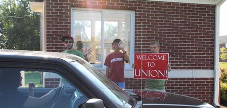 Chase Techentin, Michael Lam, and Josiah Hubin welcome new students to campus as they move in for the 2010 fall semester.  - Photo by Victoria Stargel