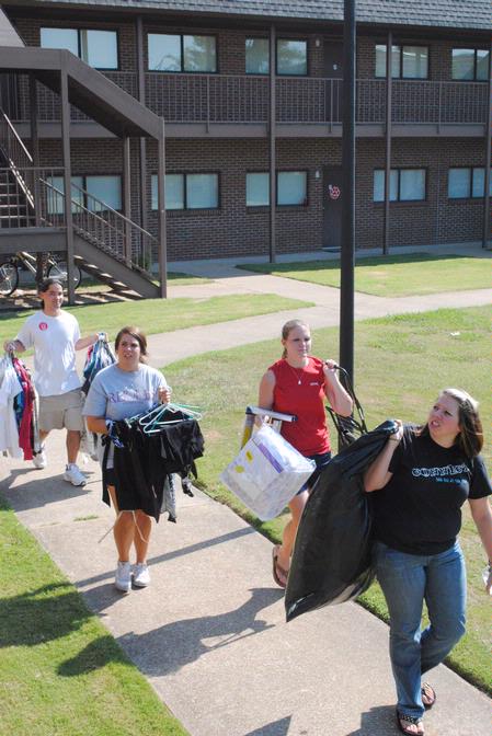 Fonsie Guilaran (far left), associate professor of physics, joins other faculty, staff, and students in helping new students move in for the fall semester.  - Photo by Victoria Stargel