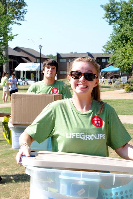 Julia Marshall, sophomore special education major,  enthusiastically carries a box full of dorm stuff for a new student on Move In Day.  - Photo by Victoria Stargel