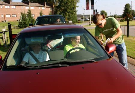 Christian Wallen, junior chemistry major, greets new students at the gate and guides them to check-in on Move In Day.  - Photo by Ebbie Davis