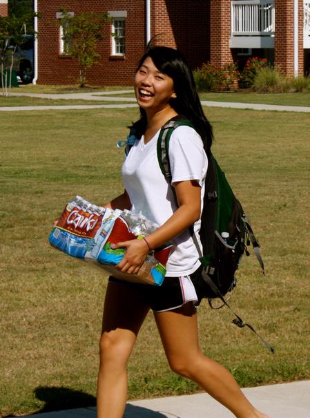 Alana Hu, incoming freshman from Memphis, TN carries some water to her dorm on Move In Day. - Photo by Ebbie Davis