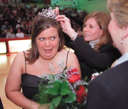 2001 Homecoming Queen Ellie (Evans) Nelson helps 2002 Homecoming Queen Sarah Jane Head with her crown at Homecoming 2002.  - Photo by Jim Veneman
