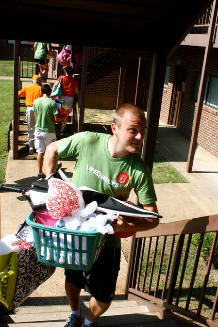 Life Group Leader, John Winfree, carries things upstairs in the Heritage Complex for a new student on Move In Day. - Photo by Ebbie Davis