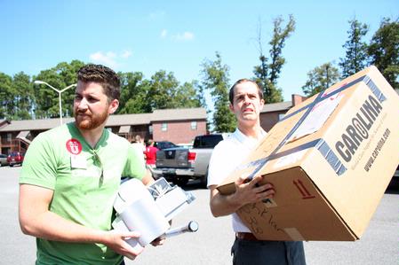 Lee Wilson, director of discipleship, and Landon Preston, director of donor relations, help a new student move into the dorms on Move In Day. - Photo by Deanna Santangelo