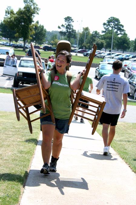 Megan Thompson, junior advertising major, carries chairs and a guitar to a new student's room on Move In Day. - Photo by Deanna Santangelo