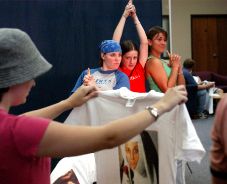 Freshmen Cassie Harris, Lindsey Abell, and Gina Orosz strike a Charlie's Angels pose for a personalized t-shirt at Fall Fest 2003. Freshman Chelsea Mytyk looks at her nun like t-shirt that was just made. - Photo by Jonathan Blair