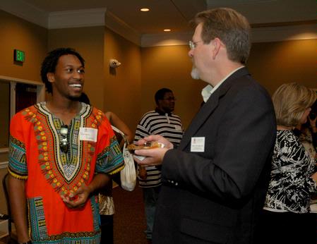 Derique Cannon, junior electrical engineer major, talks with John Netland, professor of English and department chair, at the President's Reception in the Grant Center. - Photo by Deanna Santangelo