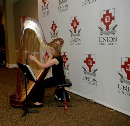Anna Wicker, senior music major, plays the harp for entertainment at the President's Reception. - Photo by Deanna Santangelo