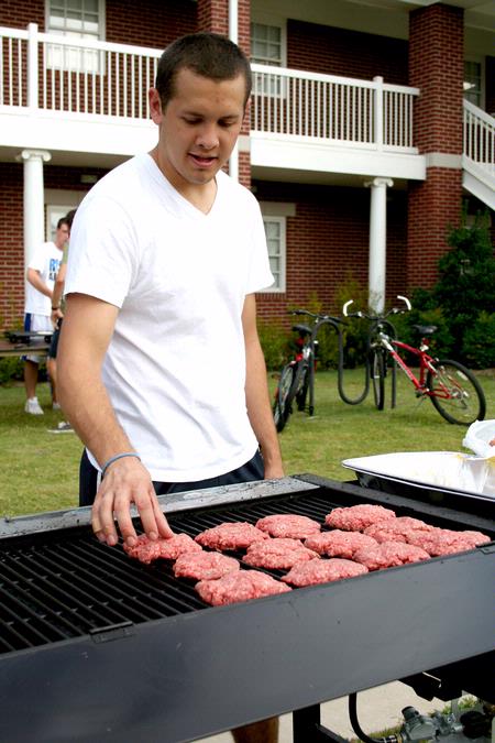 Mark Ellison, senior business administration major, cooks hamburgers at the Watters Great Outdoors event sponsored by Residence Life.  - Photo by Deanna Santangelo