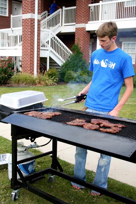 Michael Lewis, junior biology major, cooks the steaks that are rewarded to the top teams during the Watters Great Outdoors competition. - Photo by Deanna Santangelo