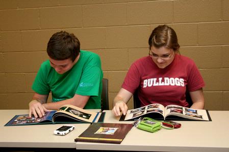 Wil Story, sophomore public relations major, and Amelia Krauss, junior journalism major, look through photo albums of Angel, Fonsi and Lesley Guilaran's adopted child.  - Photo by Deanna Santangelo
