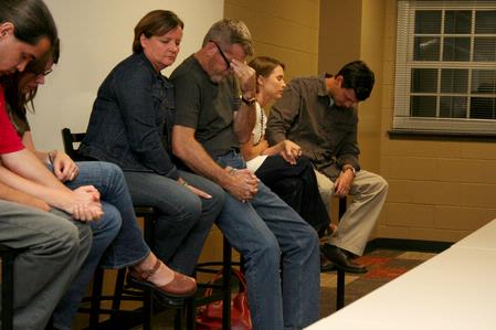 The Guilarans, the Jacksons, and the Campbells bow their heads in prayer after discussing their adoption experiences at Go Week: Reaching the Nations through Adoption.  - Photo by Deanna Santangelo