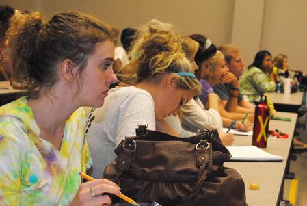 Katie Reynolds, freshman elementary education major, listens as Elizabeth Clack shares movie stories of reconciliation and healing in South Africa. Clack spoke during the Social Justice Symposium. - Photo by Victoria Stargel