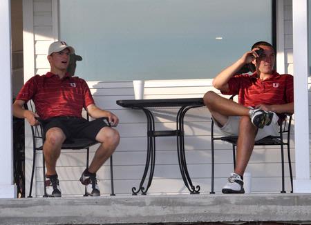 Brett Barry (left) and Micah Gentle rest after their rounds as they watch teammates come in off the course. - Photo by Steven Aldridge