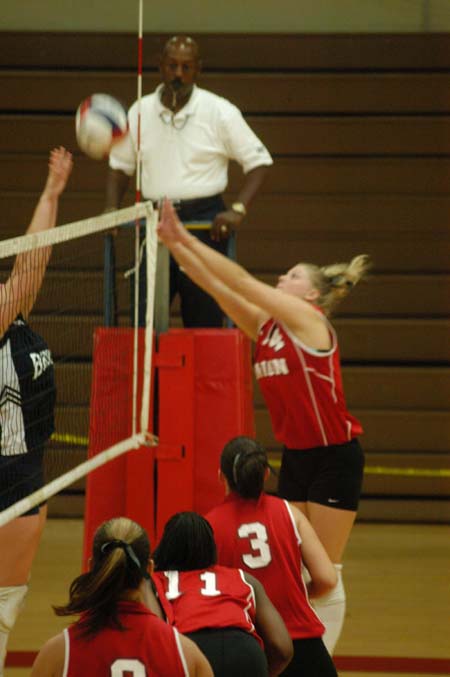 Lindsay Stahlberg (4) attempts to sneak the ball past the blocker.  Nicole Garber (3), Gladys Wandera (11), and Jennie Glassey (9) look on. - Photo by Steven Aldridge