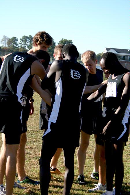 The Bulldog cross country team huddles together for prayer before a race.  - Photo by Deanna Santangelo