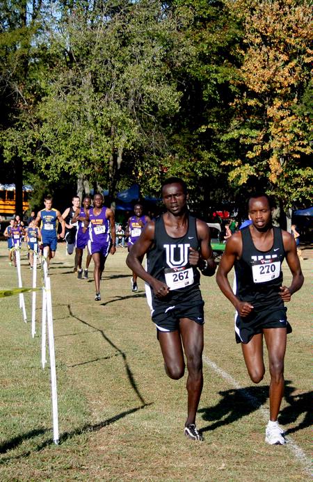 Alex Bett, junior computer science major, and Edwin Kurgat, freshman business administration major, round a corner during a cross country race.  - Photo by Deanna Santangelo