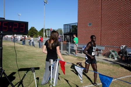 Alex Bett, junior computer science major, runs across the finish line at a cross country meet.  - Photo by Deanna Santangelo