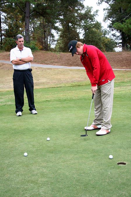 Matt Kelley, senior business major, practices his putting during a Union golf practice as Coach Andy Rushing gives pointers.  - Photo by Deanna Santangelo