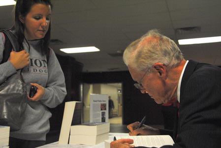 Dr. Daniel Walker Howe, Pulitzer Prize-winning author, signs a copy of his book, <em>What Hath God Wrought</em>, for Brandi Rankin, senior elementary education major. - Photo by Victoria Stargel