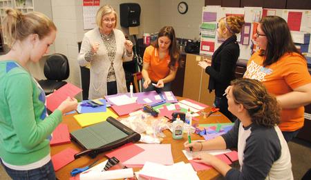 Sharon Murphy, principle of Pope Elementary School, expresses her excitement that Union students are helping make bulletin boards for her school. Union's International Justice Mission chapter volunteered to help various area schools during Campus and Community Day. - Photo by Victoria Stargel