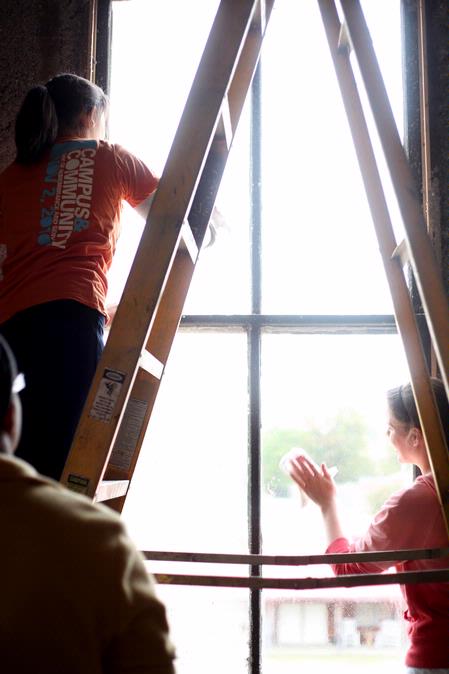 Junior history majors Caitlin Roach and Savannah German clean windows at the historic Neil House as part of the history department's project for Campus and Community Day.  - Photo by Kristi McMurry Woody