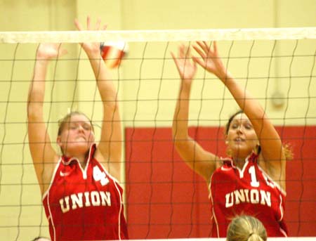 Seniors Lindsay Stahlberg (4) and Crystal Abel (12) attempt to block a shot. - Photo by Steven Aldridge