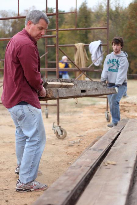 David Thomas, professor of history, works with students to move lumber at the Neil House, a historic home being restored at Casey Jones Village. The history department helped with the restoration as a part of Campus and Community Day.  - Photo by Kristi McMurry Woody