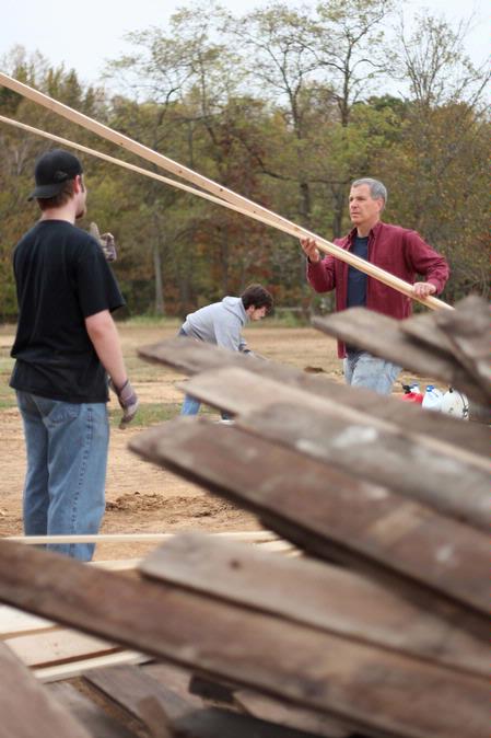 David Thomas, professor of history, works with students to move lumber at the Neil House, a historic home being restored at Casey Jones Village. The history department helped with the restoration as a part of Campus and Community Day. - Photo by Kristi McMurry Woody