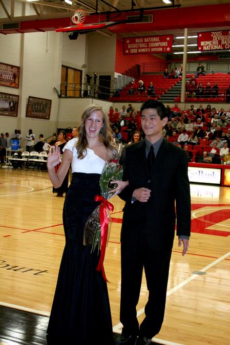 Emily Logan, senior music performance major, is escorted by her brother-in-law, Danny Song, during the presentation of the homecoming court.  - Photo by Deanna Santangelo