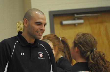 Ariel Apolonario, assistant volleyball coach, encourages the players during the game. - Photo by Morris Abernathy