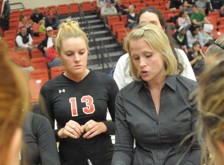 Kelly Elliott, head coach, talks to Caroline Robbins and the rest of the Lady Bulldog volleyball team during a timeout. - Photo by Morris Abernathy