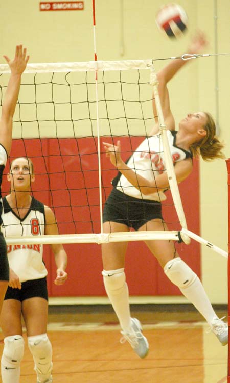 Freshman Kelly Huffines (9) reaches way back for a kill attempt.  Jenney Glassey (8) looks on. - Photo by Steven Aldridge
