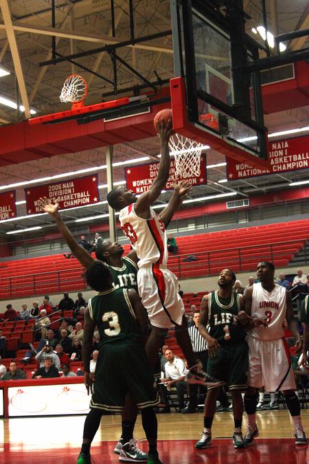 Samuel Danache goes up for a shot under the goal while Life University defensive players guard him.
 - Photo by Ebbie Davis
