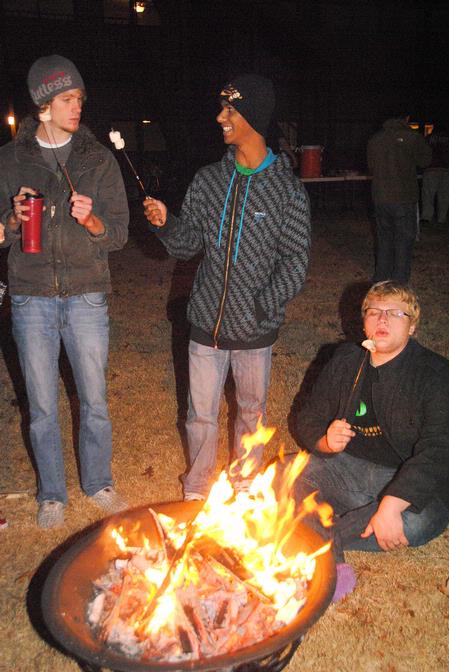 David Knack, Tommy Woods, and Adam Stanford roast marshmallows at the S'more Giving event hosted by Residence Life.  - Photo by Victoria Stargel