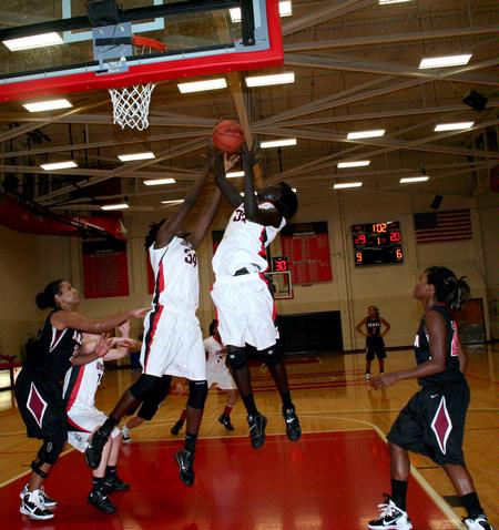 Beatrice Awino Duola and Zeinab Chan jump up for a rebound after a free-throw during a game against Azusa Pacific University during the second round of the 17th Annual Jackson Rotary Classic. - Photo by Deanna Santangelo
