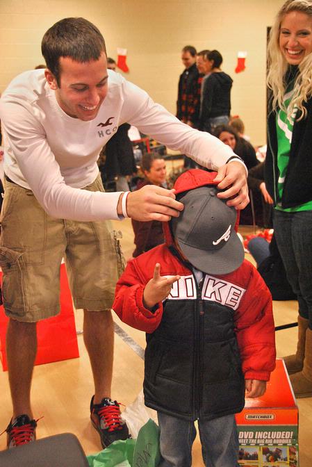 Chase Tuggle, sophomore youth ministry major, and Mazie Walthall, junior nursing major, help give Christmas gifts to a special child during the Carl Perkins Christmas Party sponsored by SAC.  - Photo by Victoria Stargel