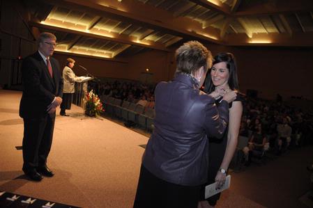 Dr. Tim Smith, dean of the school of nursing, and Carol Sykes, assistant professor of nursing, assist in the 2010 nurses pinning ceremony.  - Photo by Morris Abernathy