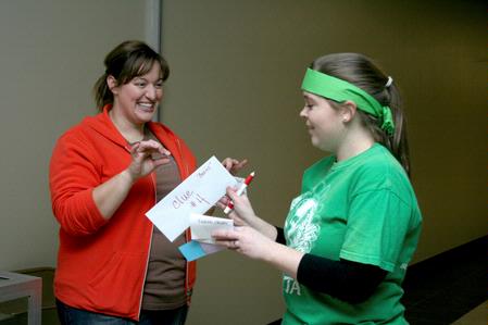 Ema VanCleave, residence director of female quads, gives Angela Patterson, senior social work major, a clue for the Residence Life event, the Amazing Race.  - Photo by Deanna Santangelo