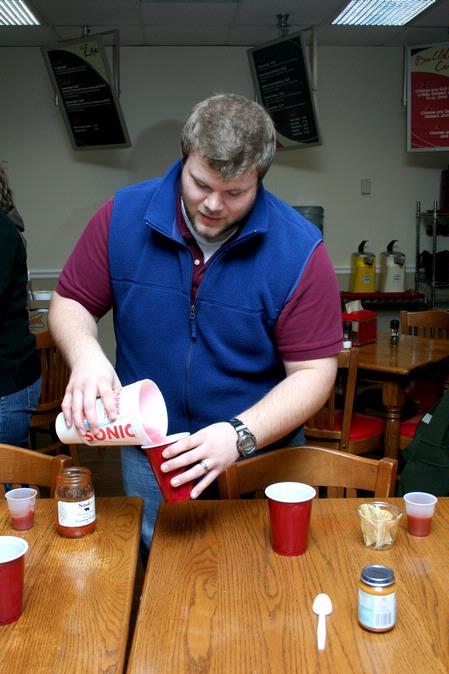 Brody Wells, husband of assistant residence director Kristin Wells, fills up drinks for a challenge during the Residence Life event the Amazing Race. - Photo by Deanna Santangelo