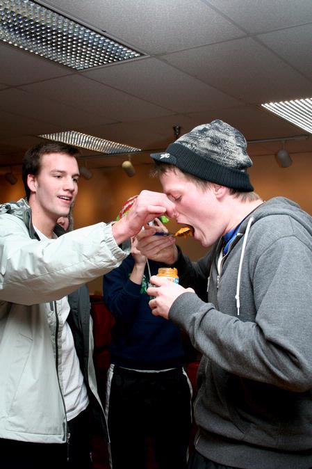 Ashton Walker, sophomore engineering major, holds the nose of Jonathan Anderson, junior art major, as he eats baby food for a challenge during Residence Life's the Amazing Race. - Photo by Deanna Santangelo