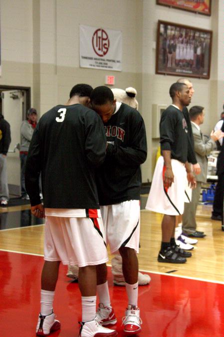 C.J. Davis and teammate Stan McNeil exchange a quick prayer before their game against Bethel University. The Bulldogs won 77-75. - Photo by Ebbie Davis
