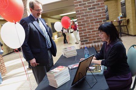 Dr. John Netland, professor of English and Department Chair, gets a book signed by guest writer Lorraine Lopez after her reading. - Photo by Abigail Harris