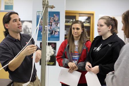 Fonsie Guilaran, associate professor of physics, helps students collect their data for a physics lab experiment on acceleration. - Photo by Kristi McMurry Woody