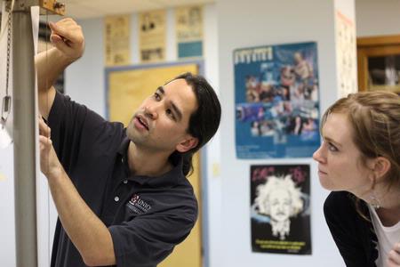 Fonsie Guilaran, associate professor of physics, helps students collect data for their lab experiment on acceleration. - Photo by Kristi McMurry Woody