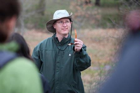 Andy Madison, associate professor of biology, shows his conservation biology students a leaf from a nearby tree during a field trip to the West TN Research & Education Center. - Photo by Kristi McMurry Woody