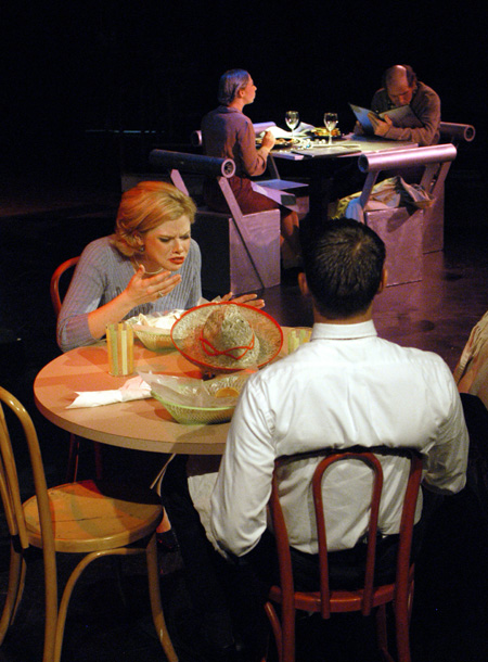 Emily Brown and Stephen Kennedy as Sandy and Harvey Gold get their first taste of dinner at Taco Circus while Patrick Myers and Miranda Wallace as Marvin and Millie Standard read their menus in the background in <i>You Have To Serve Somebody</i>. - Photo by Jim Veneman
