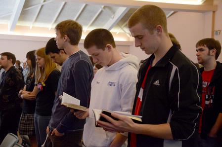 Students read along in their Bibles during chapel. - Photo by Ebbie Davis