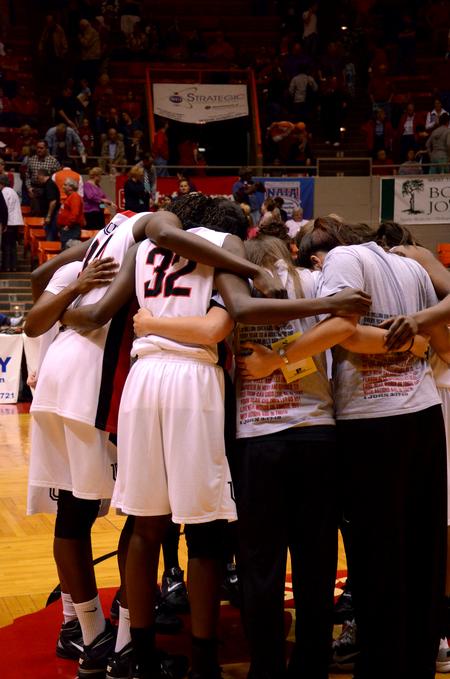 Teammates gather together and pray after the second round game of the NAIA National Championship.  - Photo by Ebbie Davis